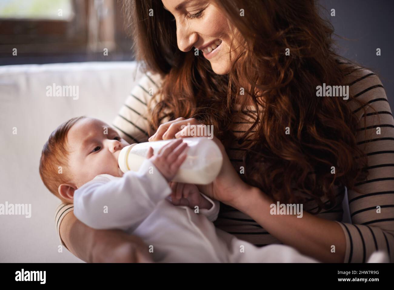 Yummy for her tummy. Cropped shot of an adoring mother feeding her baby. Stock Photo