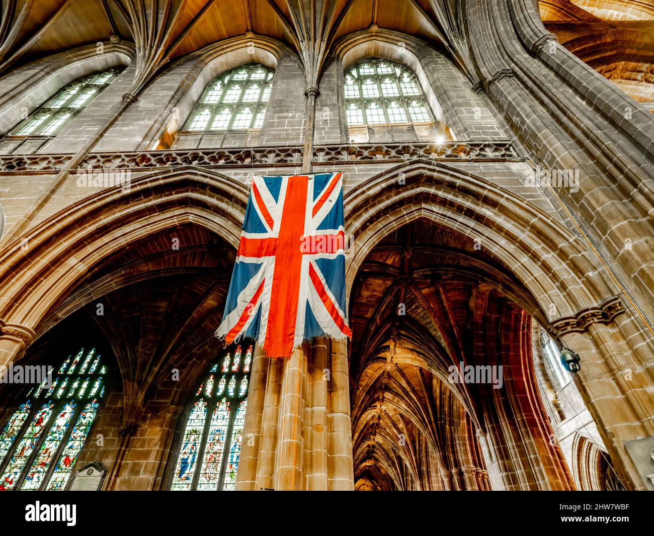 An aged weathered Union Jack hangs within Chester Cathedral Stock Photo