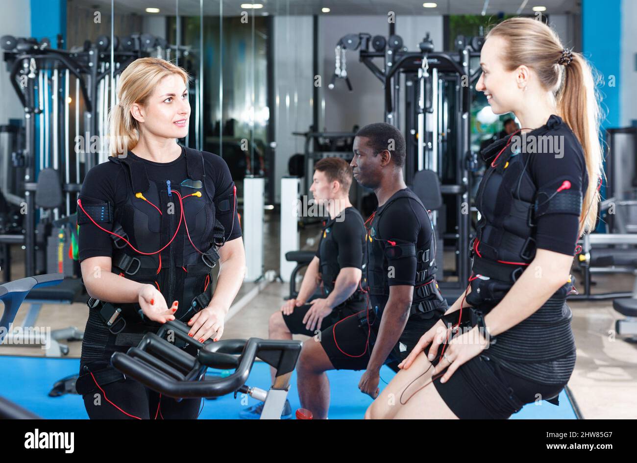 https://c8.alamy.com/comp/2HW85G7/two-fit-woman-communicating-during-electric-muscle-stimulation-workout-in-gym-2HW85G7.jpg