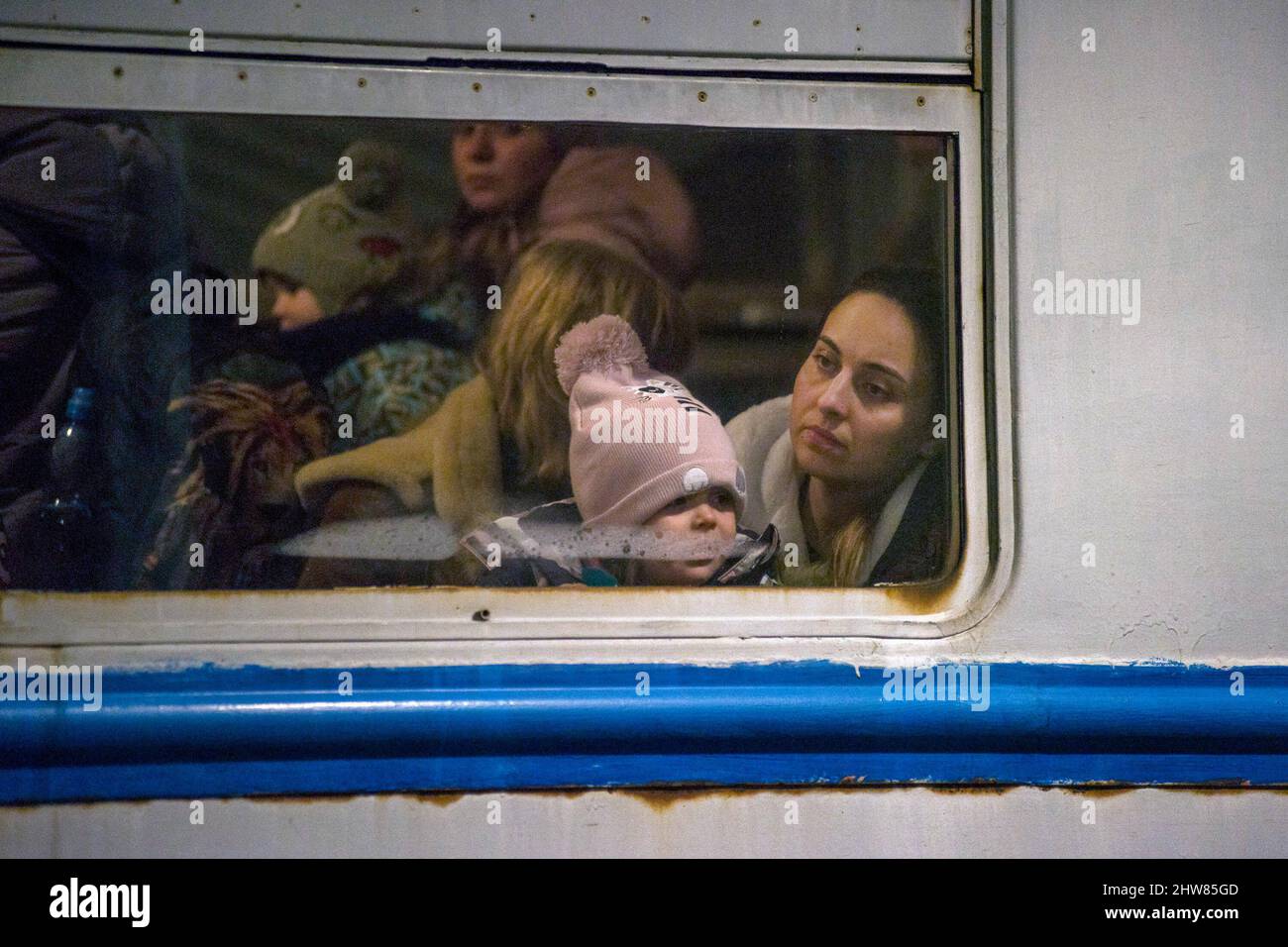 Przemysl, Poland. 03rd Mar, 2022. Ukrainian woman and her child look out through the window of the train that arrived from Ukraine to Przemysl train station. On the 8th day of the Russian invasion in Ukraine thousands of exhausted refugees fleeing war are arriving to the Polish border town of Przemysl. Credit: SOPA Images Limited/Alamy Live News Stock Photo