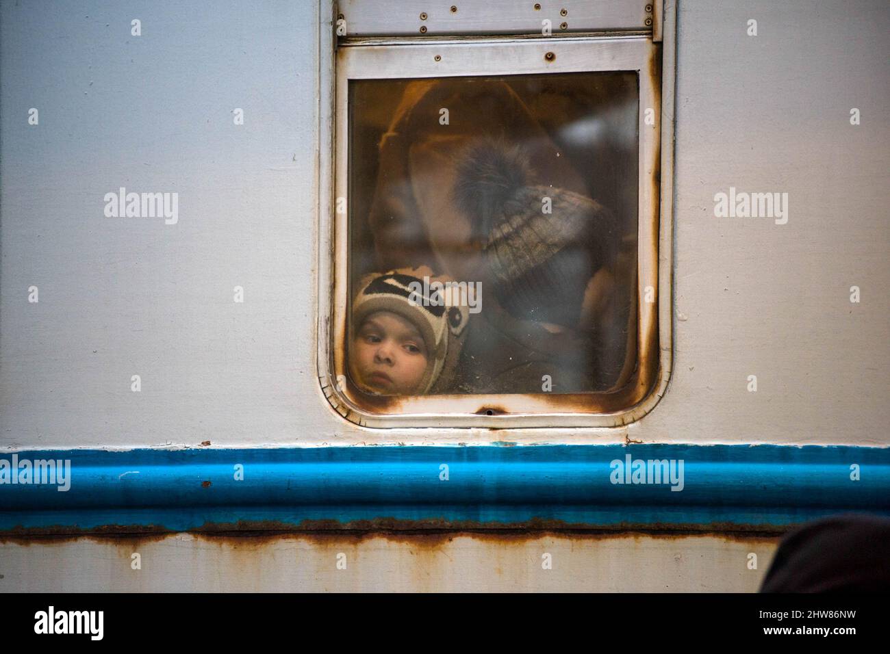 A boy looks out through the window of the train that arrived from Ukraine to Przemysl train station. On the 8th day of the Russian invasion in Ukraine thousands of exhausted refugees fleeing war are arriving to the Polish border town of Przemysl. (Photo by Attila Husejnow/SOPA Images/Sipa USA) Credit: Sipa USA/Alamy Live News Stock Photo