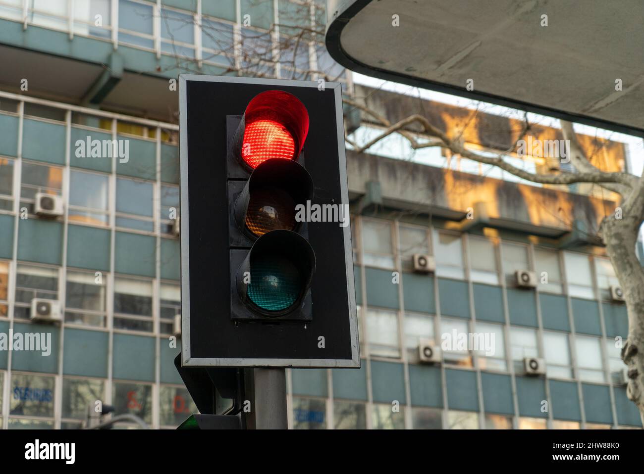 Closeup shot of traffic lights showing red light in the street with an