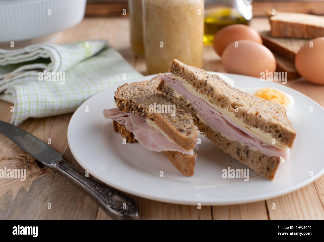 Homemade breakfast sandwich with butter, ham and cheese. Served on multigrain bread Stock Photo