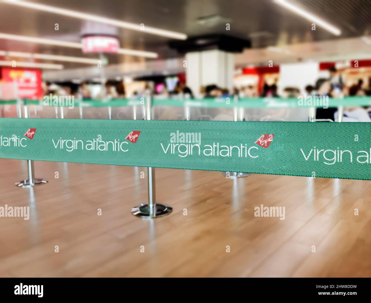 London, UK, July 2019: Green belt barrier with white Virgin Atlantic airlines logo. Virgin Atlantic is a British airline. Travel and airport security Stock Photo