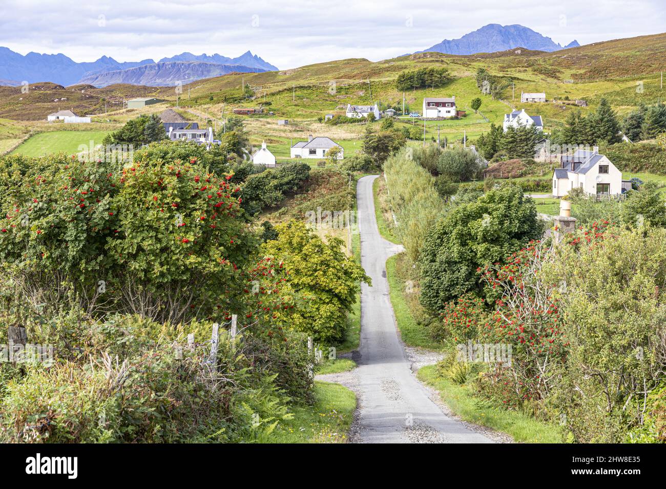 The lane to the village of Tarskavaig on the Sleat Peninsula in the south of the Isle of Skye, Highland, Scotland UK. The Cuillins are on the horizon. Stock Photo