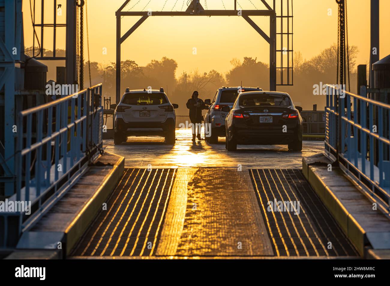 Ferry attendant collecting fees at the St. Johns River Ferry for transport to the Mayport Landing just after sunrise in Jacksonville, Florida. (USA) Stock Photo