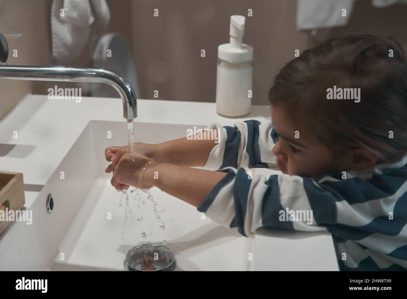Caucasian little girl washing hands in the bathroom Stock Photo - Alamy