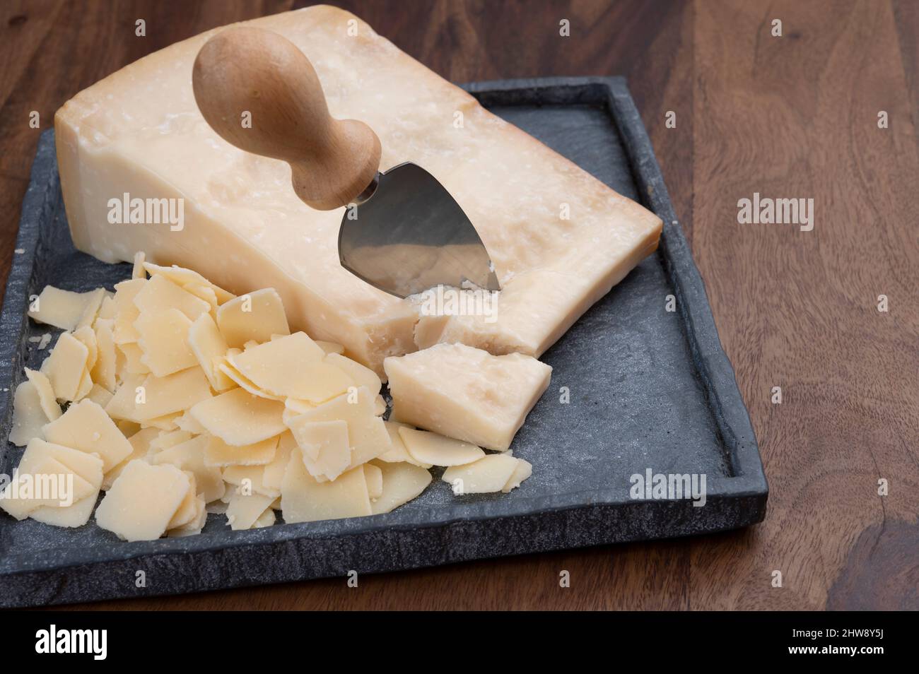 Italian hard cheese with grater on wooden background Stock Photo - Alamy