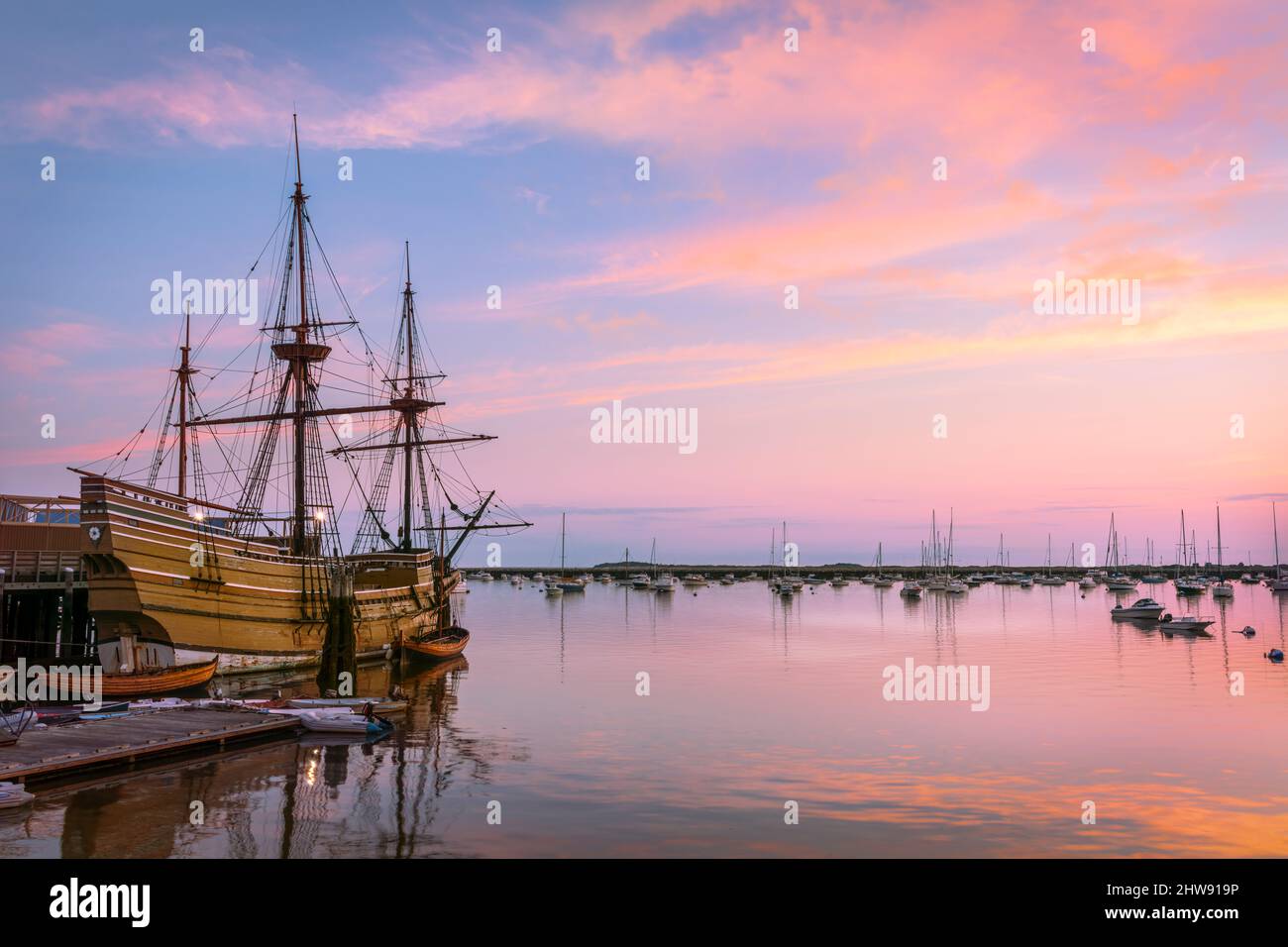 The sun rises over the Mayflower II, a replica of the 17th century Mayflower moored off State Pier in Plymouth, Massachusetts - USA. Stock Photo