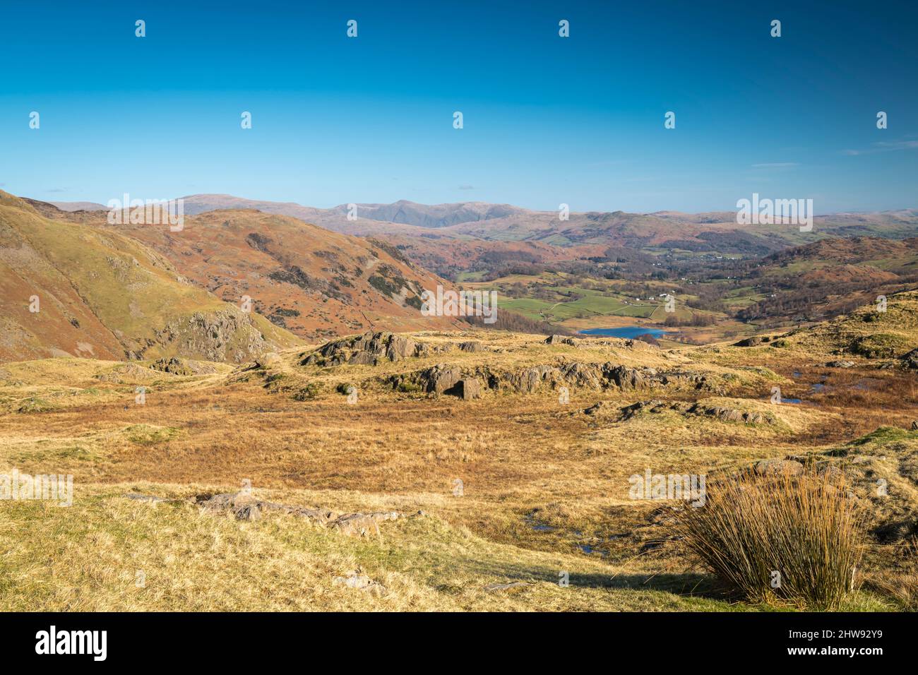 A sunny, winter, landscape HDR image looking east across the lakeland fells with a distant Helvellyn and Howgill fells, Cumbria, England.01 March 2022 Stock Photo