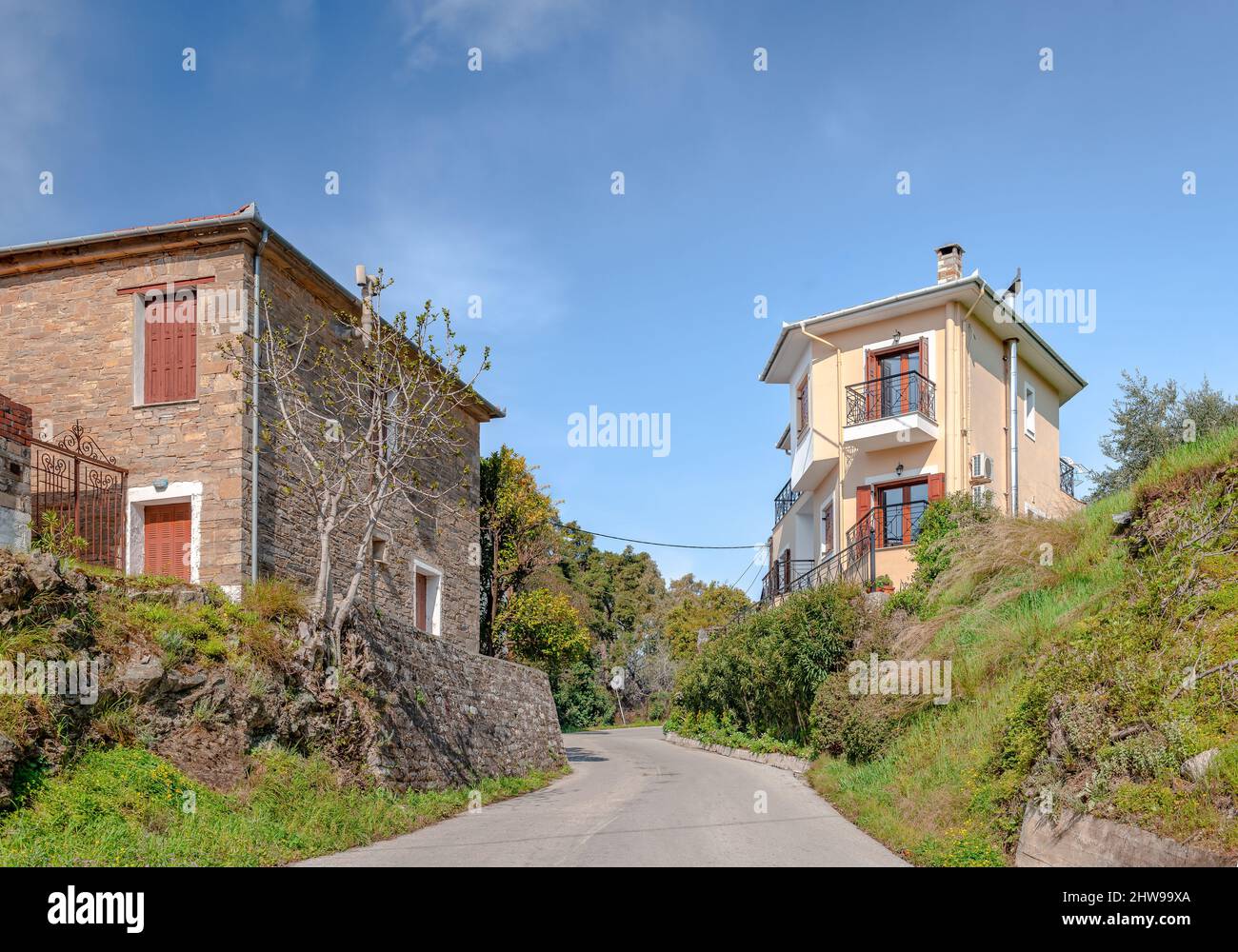 Two houses across the street that enters Afissos, a small traditional village and summer resort built on the southern side of Mount Pelion, in Greece. Stock Photo