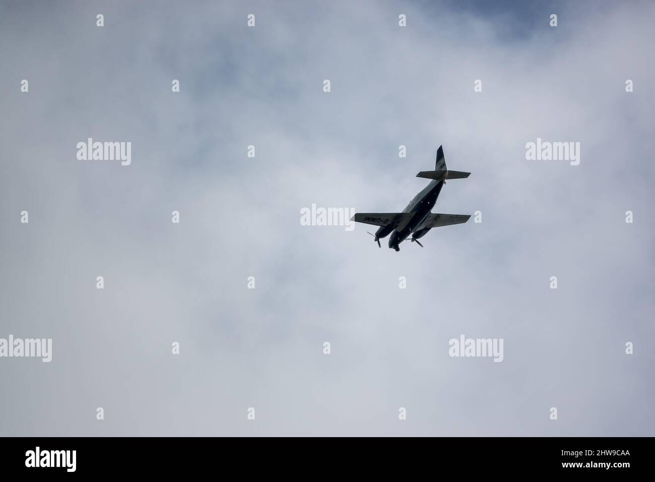 Piper PA-31-310 Navajo C, G-UMMI twin engined cabin class aircraft with surveillance equipment flying over Salisbury Plain military training area UK Stock Photo