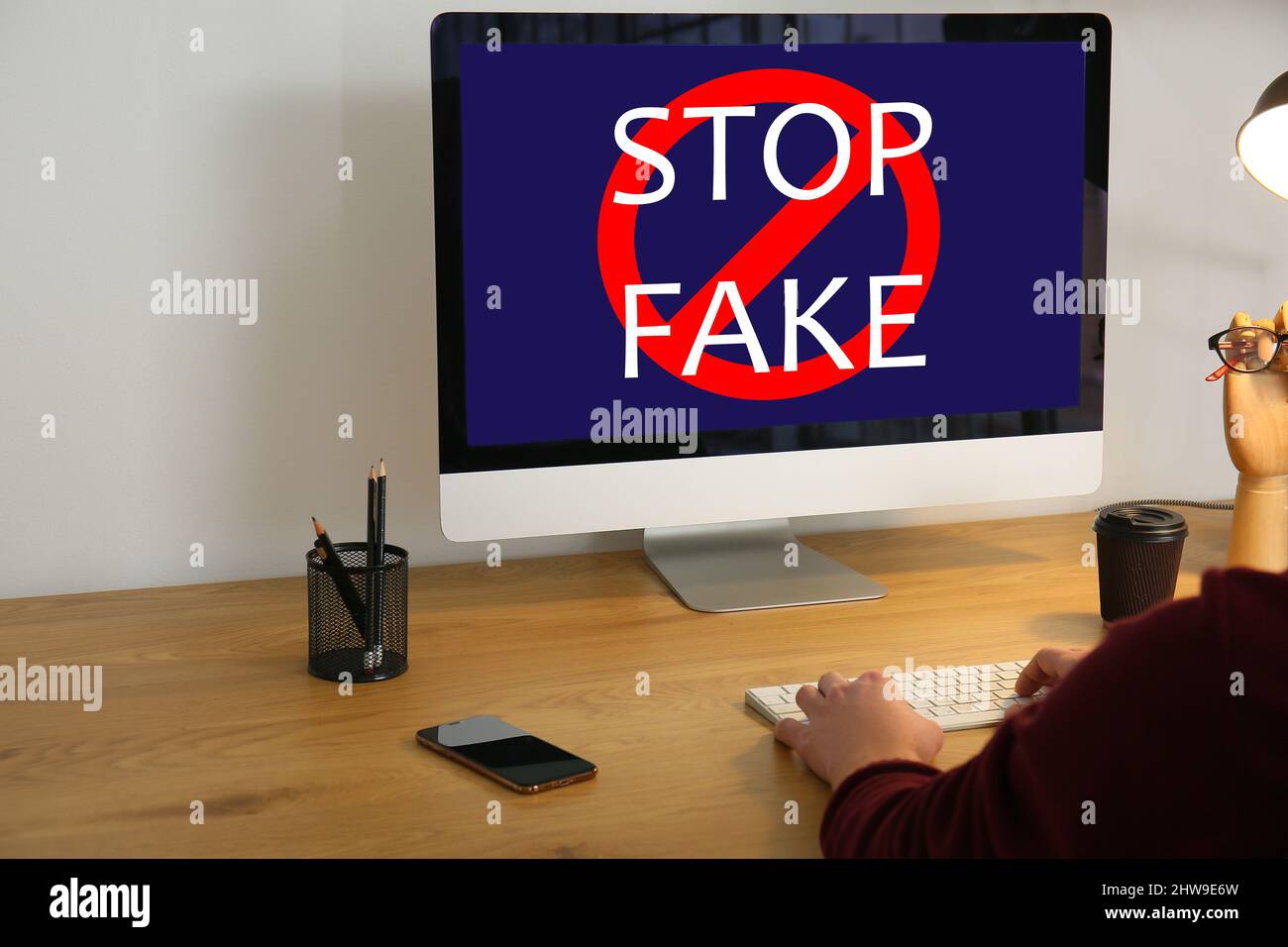 Text STOP FAKE on screen of computer monitor on table Stock Photo - Alamy