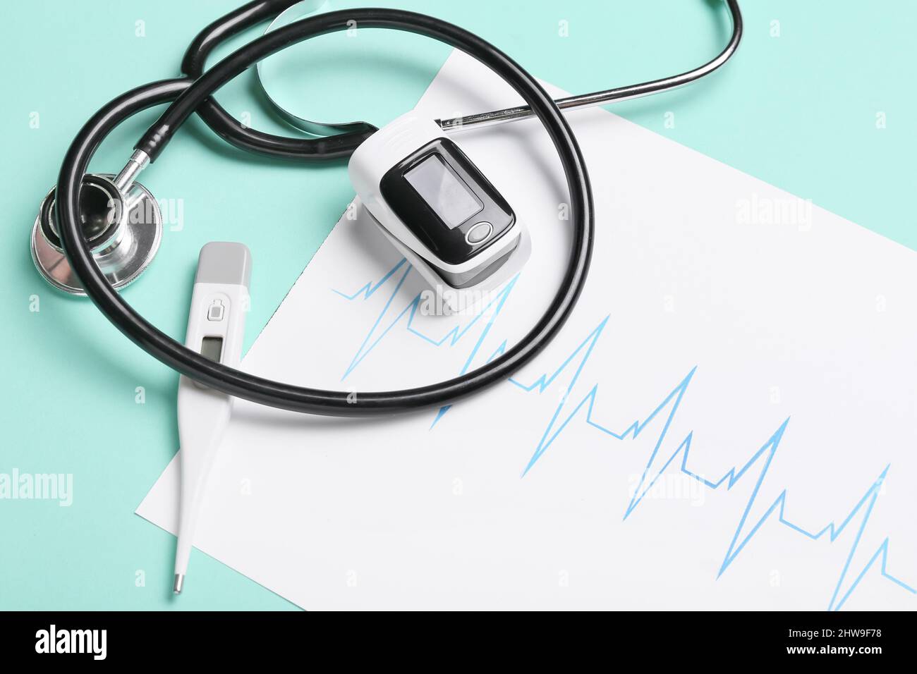 Pulse oximeter, stethoscope, thermometer and cardiogram on color ...