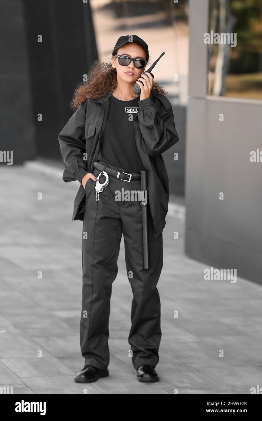 African-American female security guard with radio transmitter near ...