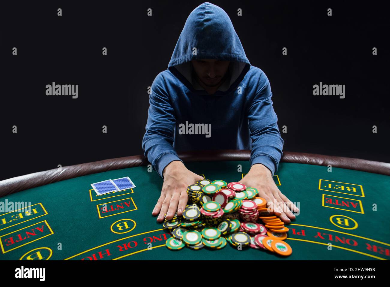 Poker player going all-in pushing his chips forward Stock Photo - Alamy