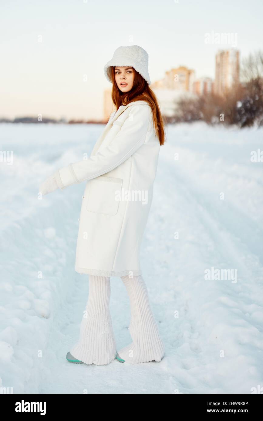 young woman in a white coat in a hat winter landscape walk Fresh air