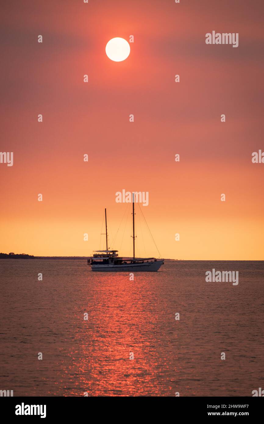 Vertical photo of a boat in the sea at sunset Stock Photo - Alamy