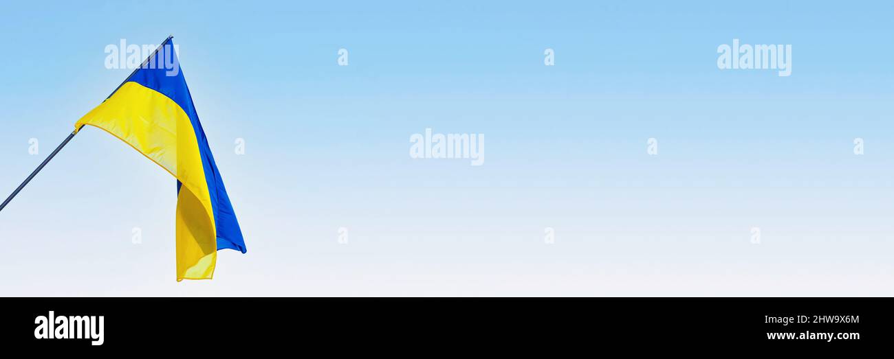 Ukraine national flag waving in wind against sky. Panorama format with ...