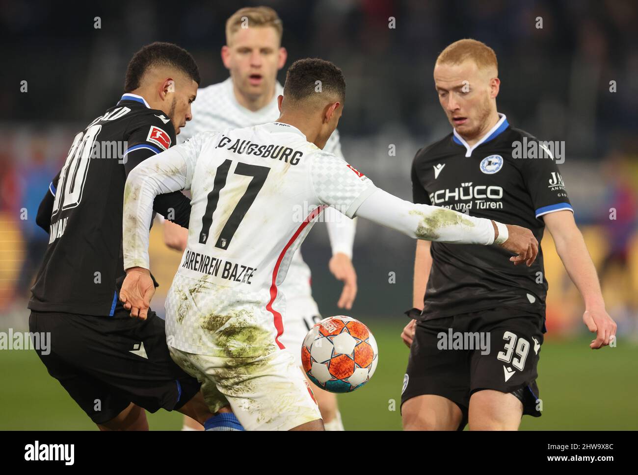 Bielefeld, Germany. 04th Mar, 2022. Soccer: Bundesliga, Arminia Bielefeld - FC Augsburg, Matchday 25 at the Schüco Arena. Bielefeld's Andres Andrade (l) battles for the ball with Augsburg's Noah Joel Sarenren Bazee (2nd from left). Credit: Friso Gentsch/dpa - IMPORTANT NOTE: In accordance with the requirements of the DFL Deutsche Fußball Liga and the DFB Deutscher Fußball-Bund, it is prohibited to use or have used photographs taken in the stadium and/or of the match in the form of sequence pictures and/or video-like photo series./dpa/Alamy Live News Stock Photo