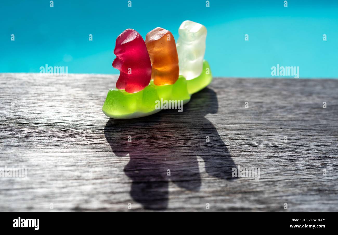 Three сolorful jelly gummy bears on a jelly gummy crocodile Stock Photo