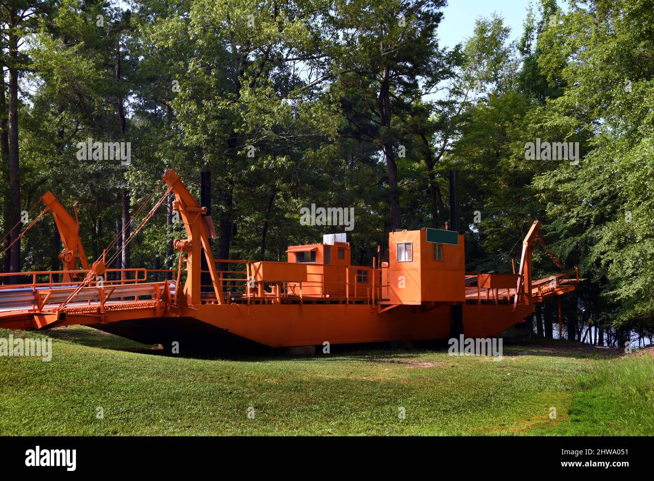 Bright orange, Moro Bay Ferry, which ferried vehicles across Ouachita River, is a historic ferry displayed at the Moro Bay State Park in Arkansas. Stock Photo