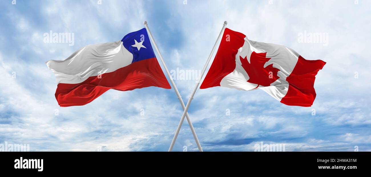 crossed national flags of Chile and canada flag waving in wind at ...