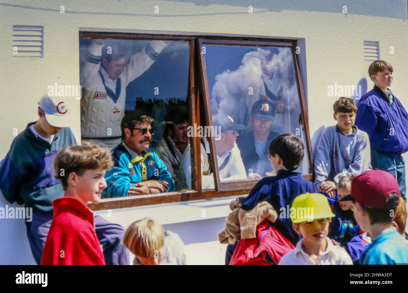 10 July 1993 International Cricket - One day exhibition game, Ireland v Australia at Castle Avenue, Clontarf, Dublin, Ireland. David Boon (front left) with Shane Warne beside him watch the game from the changing room. Neither played in the game.  (Scorecard - Australia 361/3 declared. Ireland 89 all out. Australia won by 272 runs) Stock Photo