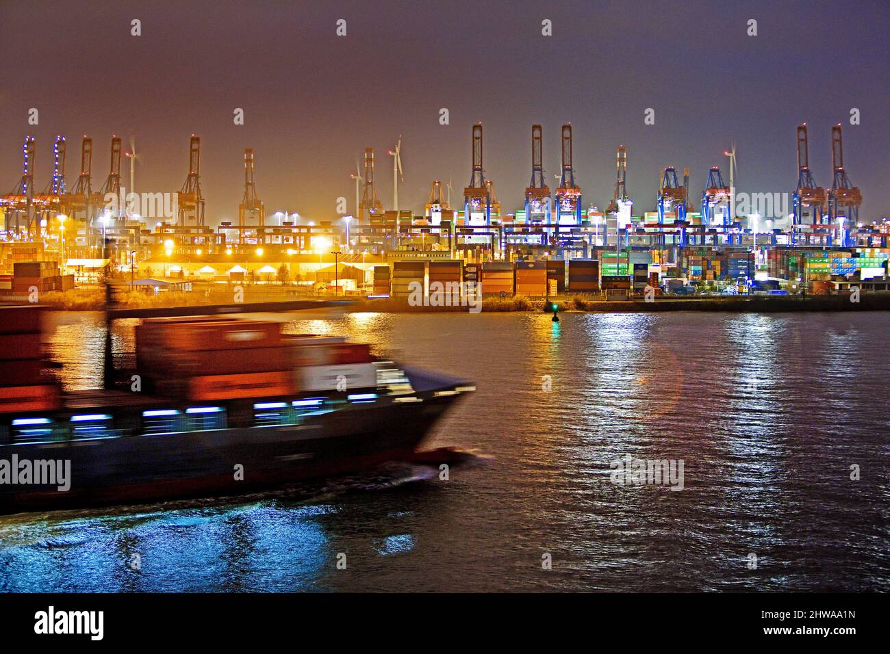 Container ship on Norderelbe in front of cranes at container terminal Burchardkai at night, Port of Hamburg, Germany, Hamburg Stock Photo