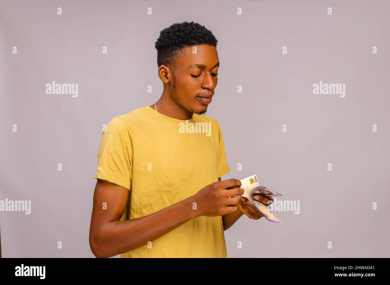 handsome african boy isolated over white background counting his salary