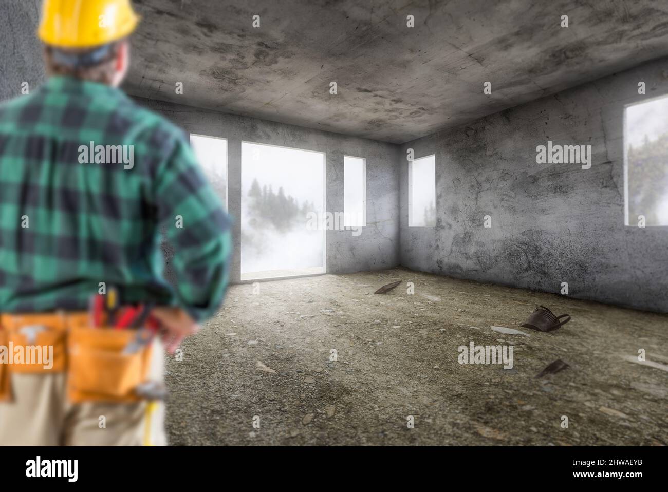 Contractor In Hard Hat and Construction Belt Facing Vacant Empty Abandoned Room of House. Stock Photo
