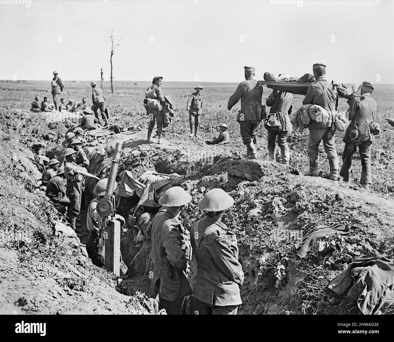Troops of the 3rd Battalion, Grenadier Guards, in the old German second line during Attack on Moyenneville. There are German prisoners and wounded coming in. Note tanks in distance. 21 August 1918. (Note Lewis gun mounted for use against aircraft). Stock Photo