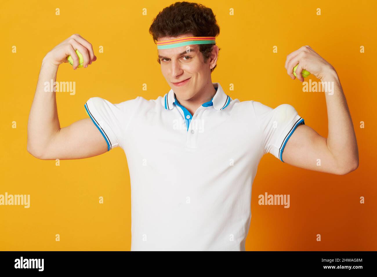 He has a trick up his sleeve. A young man in tennis attire hiding