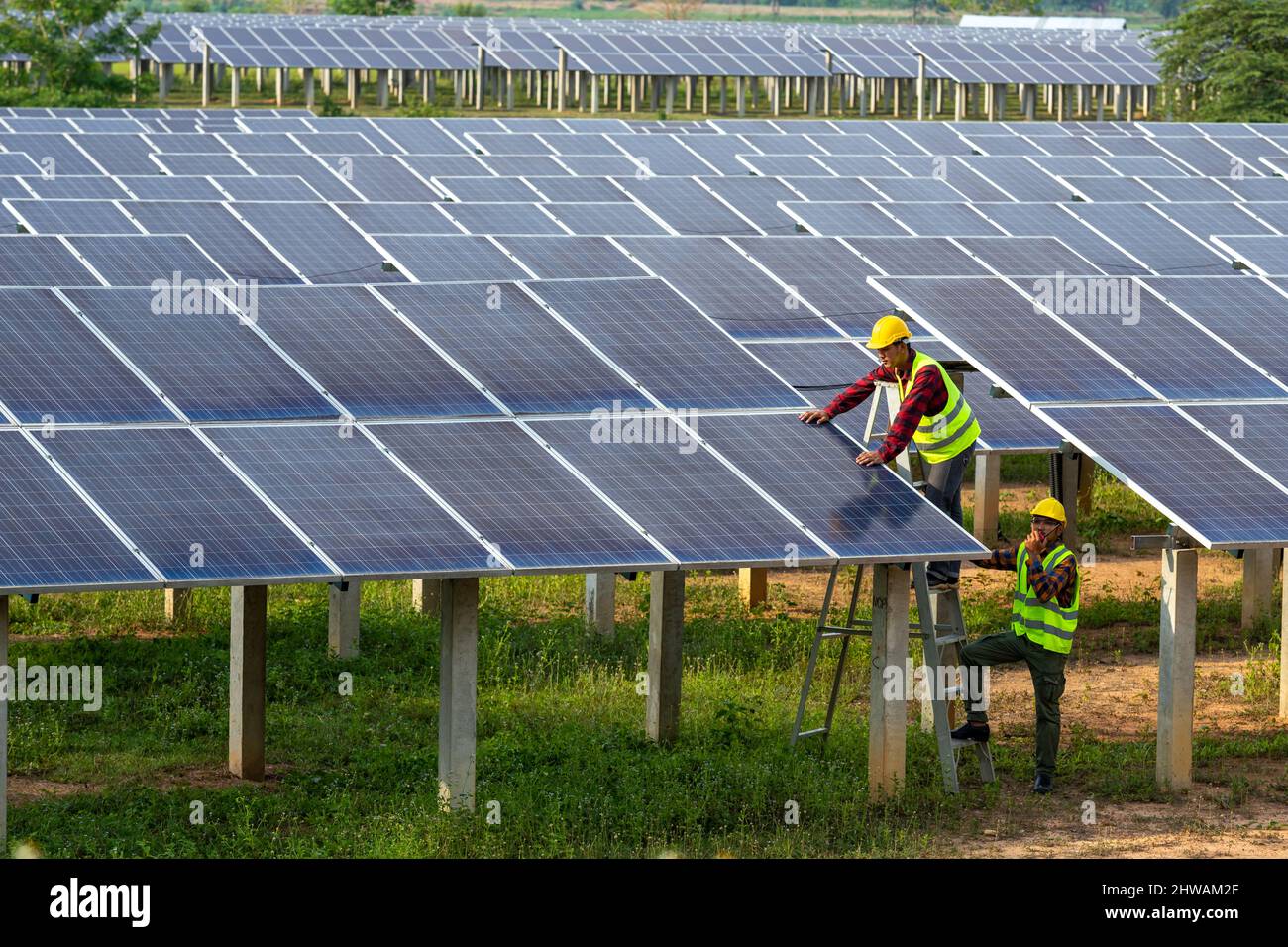 Asian team electrician installing solar panels working on alternative energy sources clean, Solar Power. Stock Photo