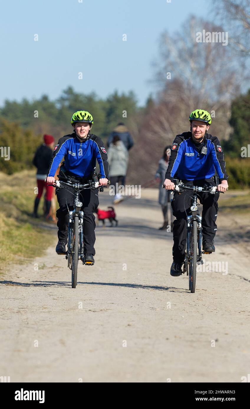 Undeloh, Germany. 02nd Mar, 2022. The two police officers, Valerie Janke (l) and Philipp Schütt, drive through the Lüneburg Heath to monitor the leash requirement. In the northern Lüneburg Heath, the Harburg Police Inspectorate monitors the leash requirement for dogs during the lambing season. Again and again, free-roaming four-legged friends cause panic in the herds of heidschnucken. Credit: Philipp Schulze/dpa/Alamy Live News Stock Photo