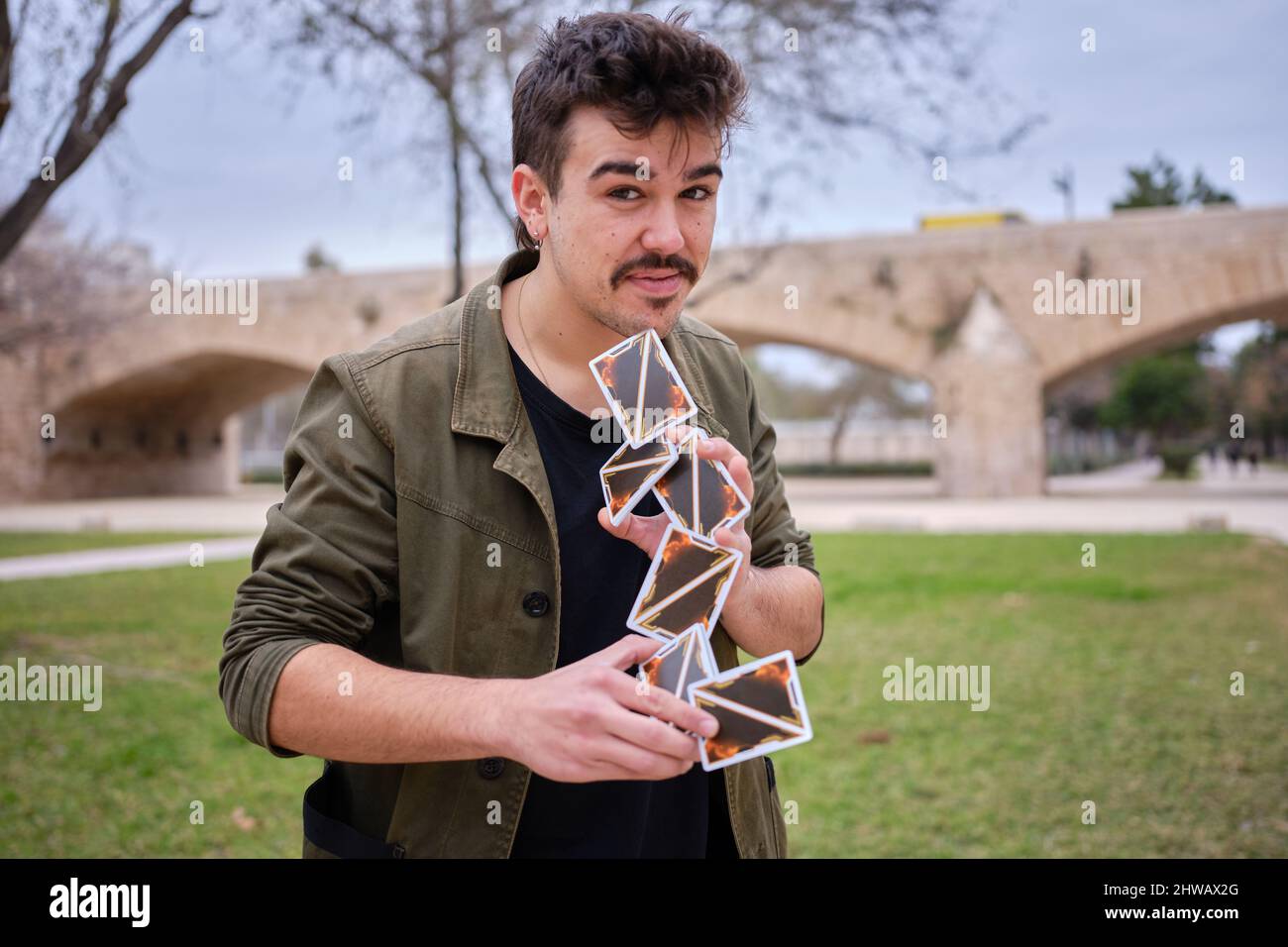 Street magician making a card castle in the air while performing a trick Stock Photo