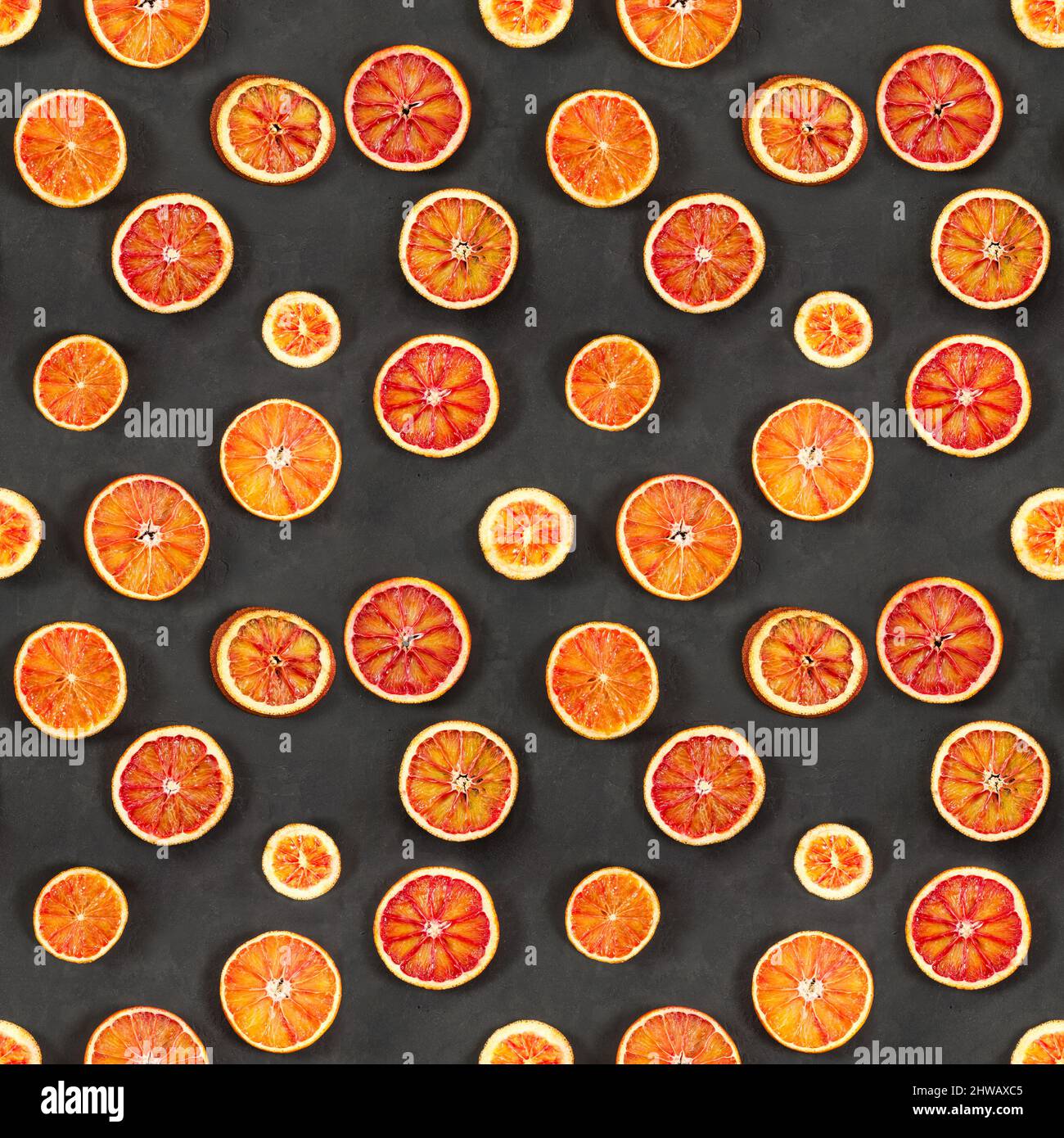 Seamless pattern with red bloody oranges on black stone background. Stock Photo