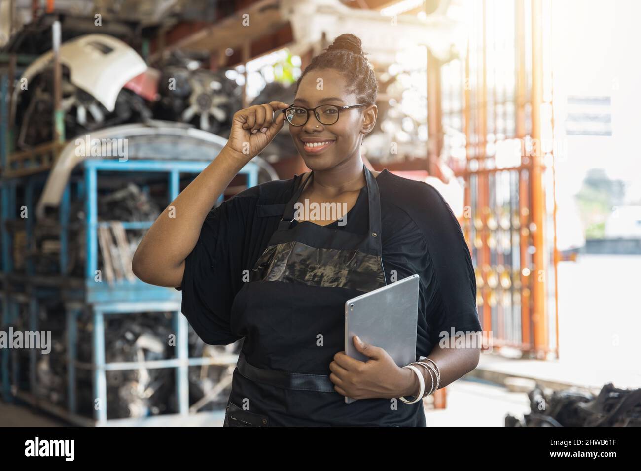 Portrait of confident African woman in old parts of car factory Stock Photo