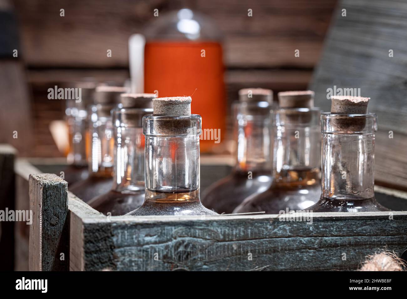 Aged whisky and wooden box with bottles in distillery. Glass of whiskey ...