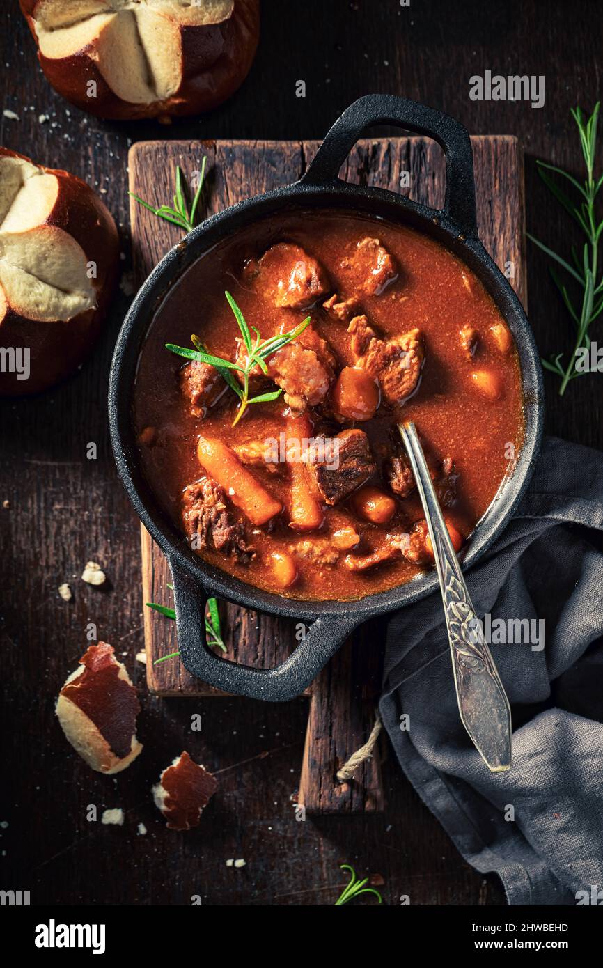 Homemade and tasty goulash made of beef and vegetables on dark plate Stock Photo