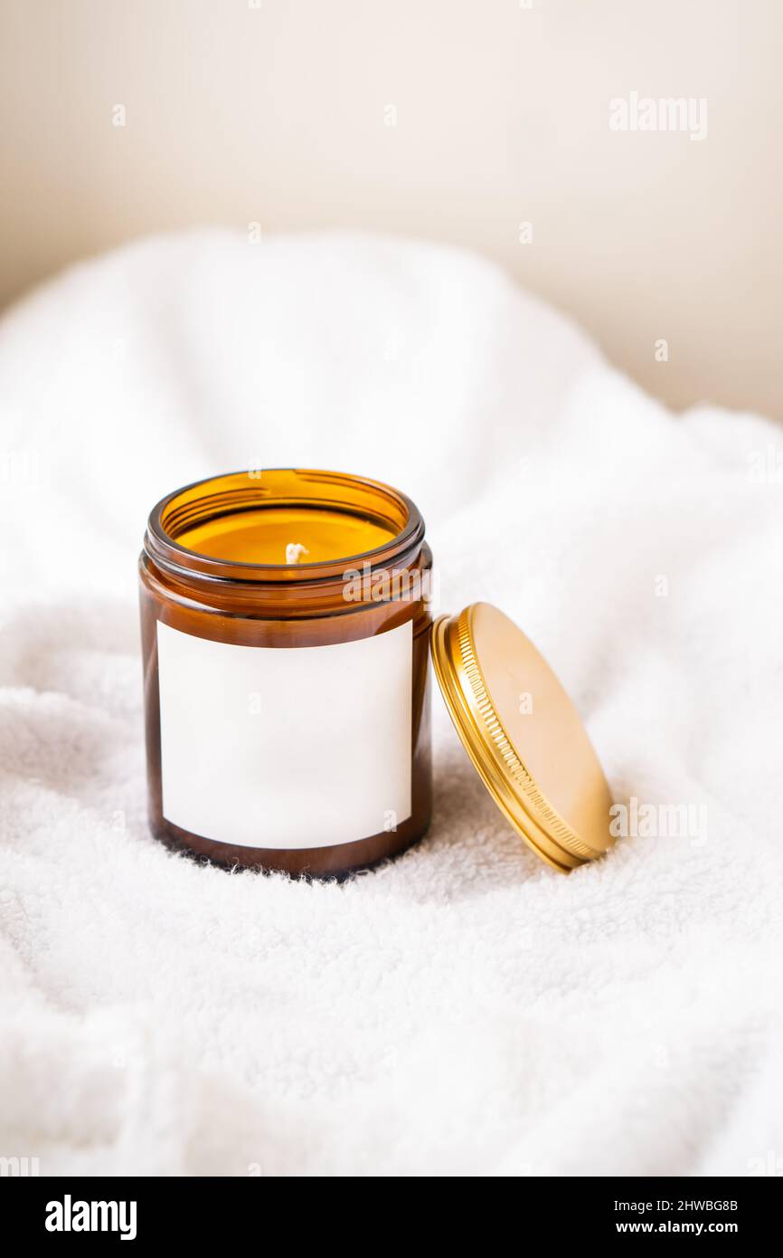 Natural wax candle in brown glass jar with metal lid and white empty ...