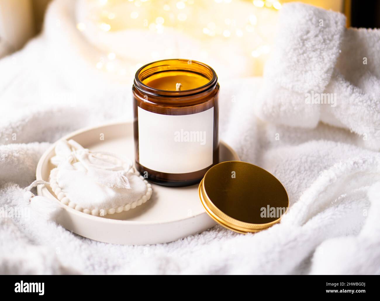 Natural wax candle in brown glass jar with metal lid and white empty ...