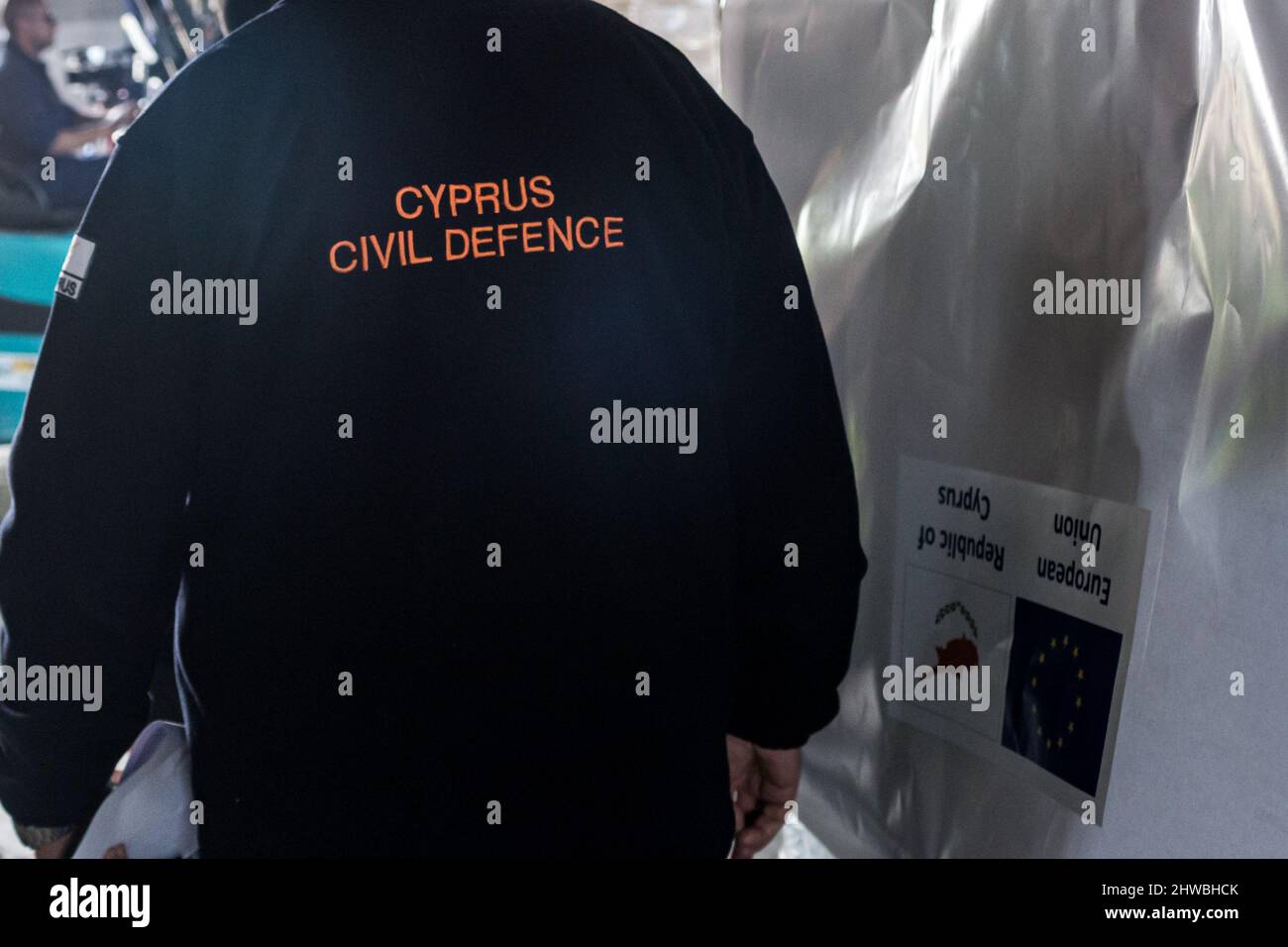 Limassol, Cyprus. 05th Mar, 2022. A man wears a jacket that reads Cyprus  Civil Defense next to a pallet with a sticker with EU and Cyprus Republic  logo, Limassol, Cyprus, on Mar.