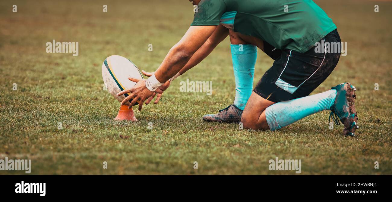 rugby player preparing to kick the oval ball during game Stock Photo