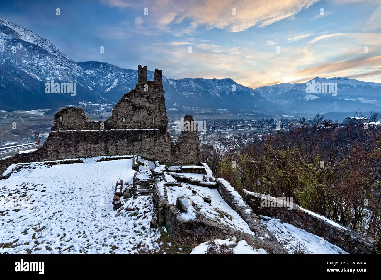 The crenellated ruins of Selva Castle and the Valsugana plain. In the background Cima Vezzena. Levico Terme, Trentino, Italy. Stock Photo