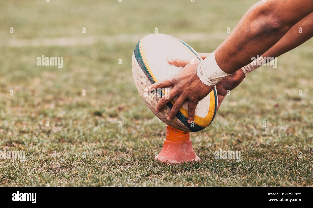 rugby player preparing to kick the oval ball during game Stock Photo