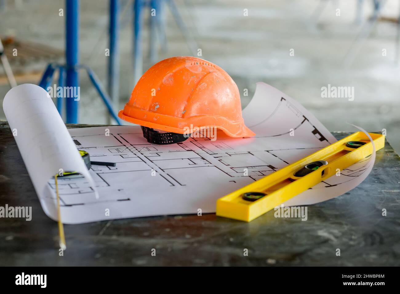 Blueprints project building, construction level and helmet, close up. Construction concept. Stock Photo