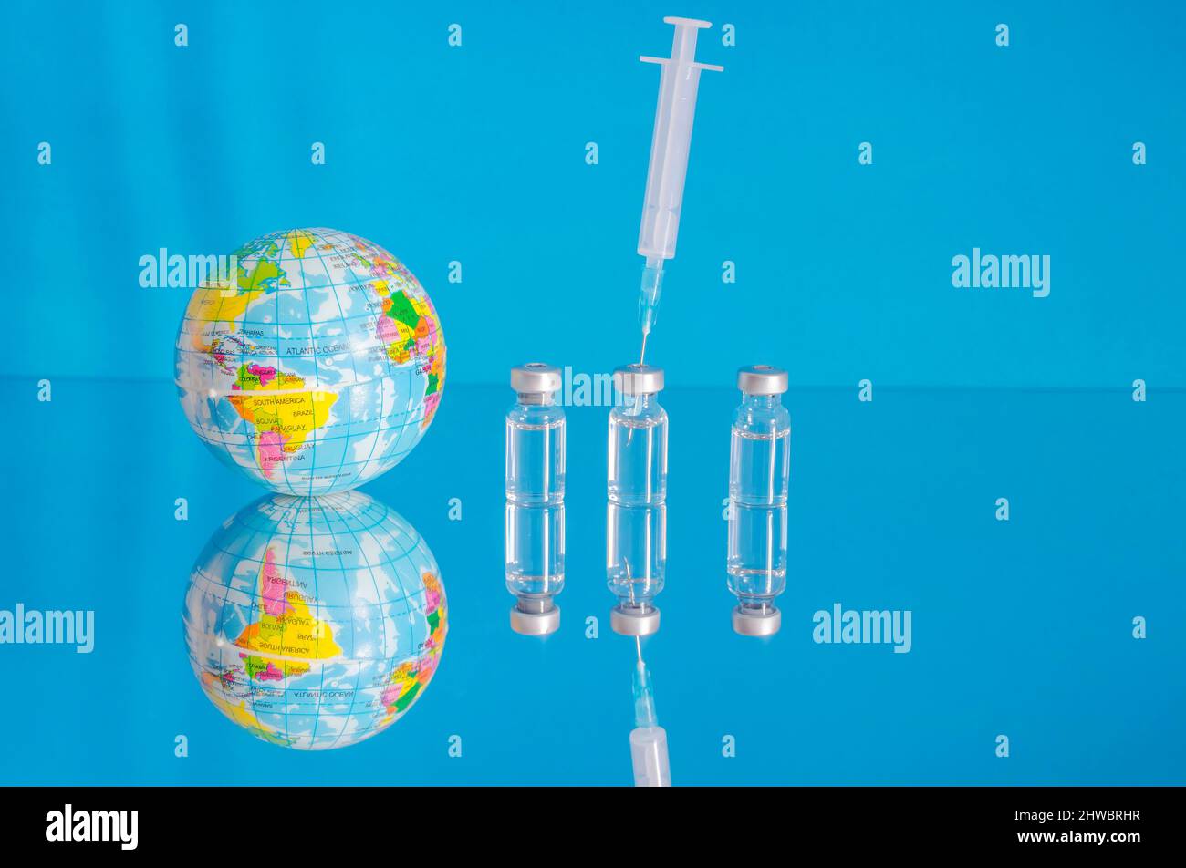 Vaccine bottles and syringe, treatment for COVID-19, influenza or flu, worldwide mass vaccination for coronavirus, global immunization concept with th Stock Photo