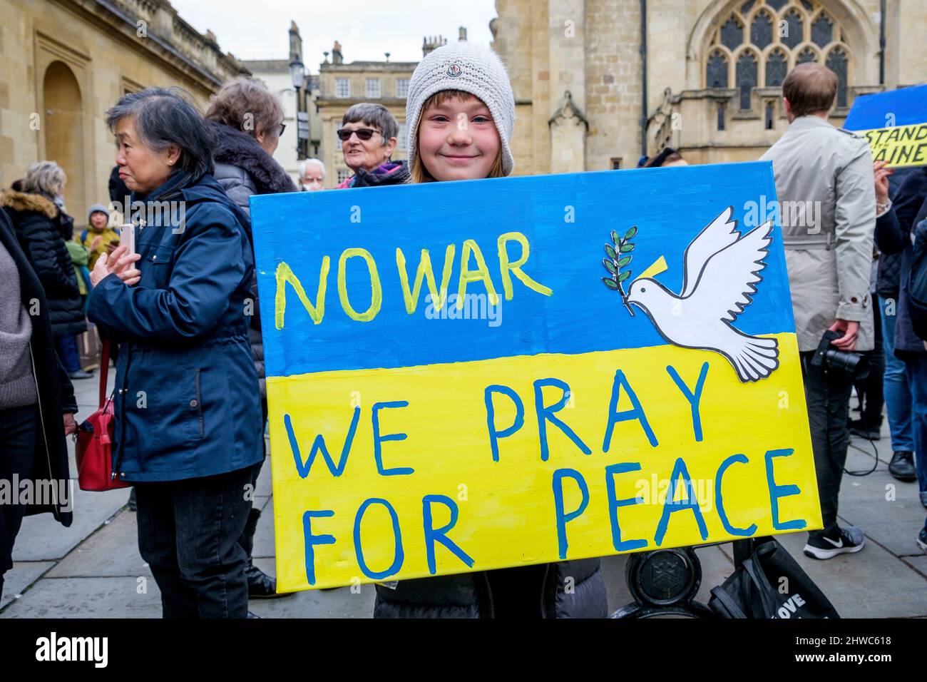 Bath, UK. 5th March, 2022. A child holds up an anti war placard in front of Bath Abbey during a demonstration against Russia's invasion of Ukraine. The demonstration was organised in order to allow local people to show their solidarity with Ukraine in the Russia-Ukraine war and to condemn Putin's actions. Credit: Lynchpics/Alamy Live News Stock Photo