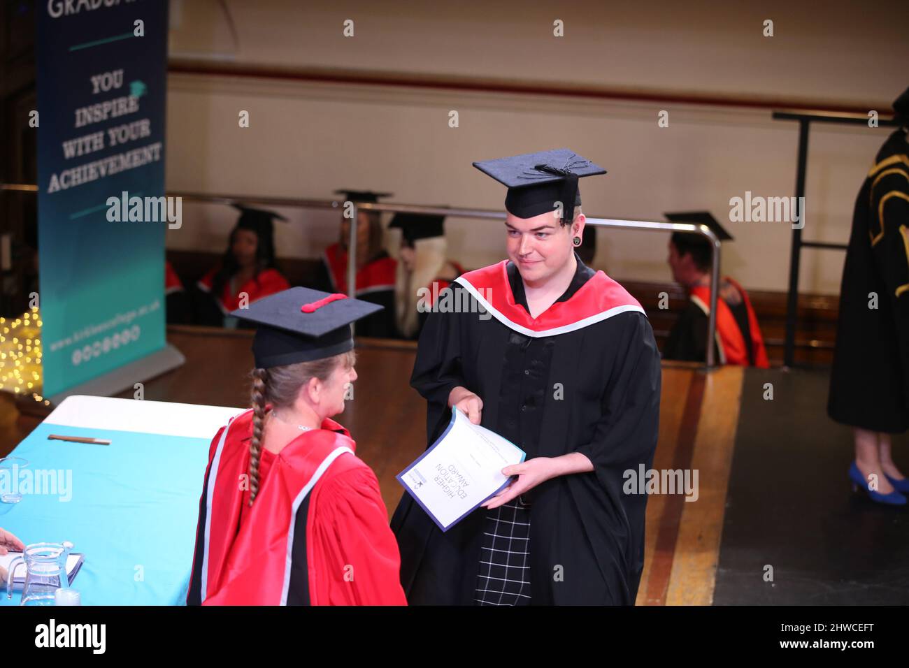 An European Graduate receives their degree at their graduation day ceremony. This formal event where graduands (before) change into graduates (after) Stock Photo